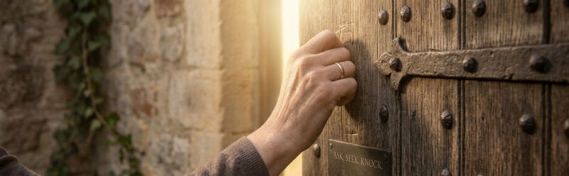 A close-up photograph of a woman’s hand, wedding band visible, knocking firmly and persistently on a weathered, heavy wooden monastery door.